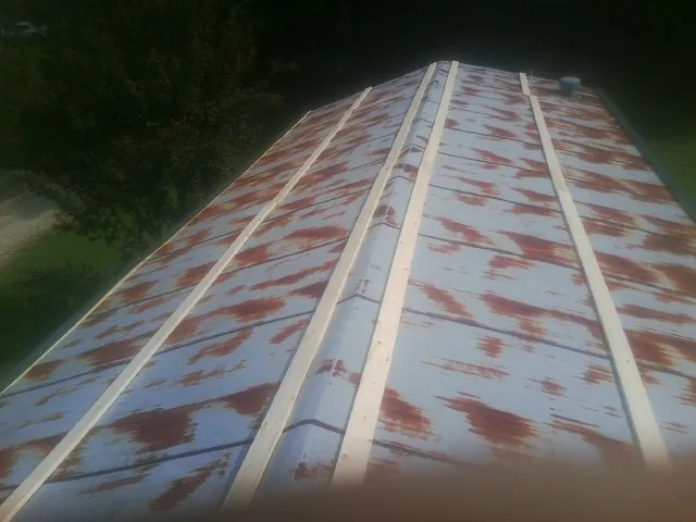 Rusted metal roof panels with new wood purlins before replacement — Storm Damage Roof Repair in Beasley by Roofing Brothers