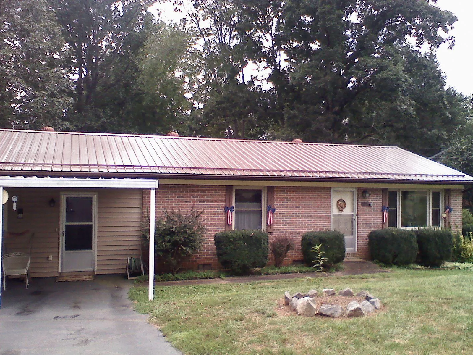 Bronze metal roof and carport on a brick ranch home — Roof Repair work by our crew in Beasley