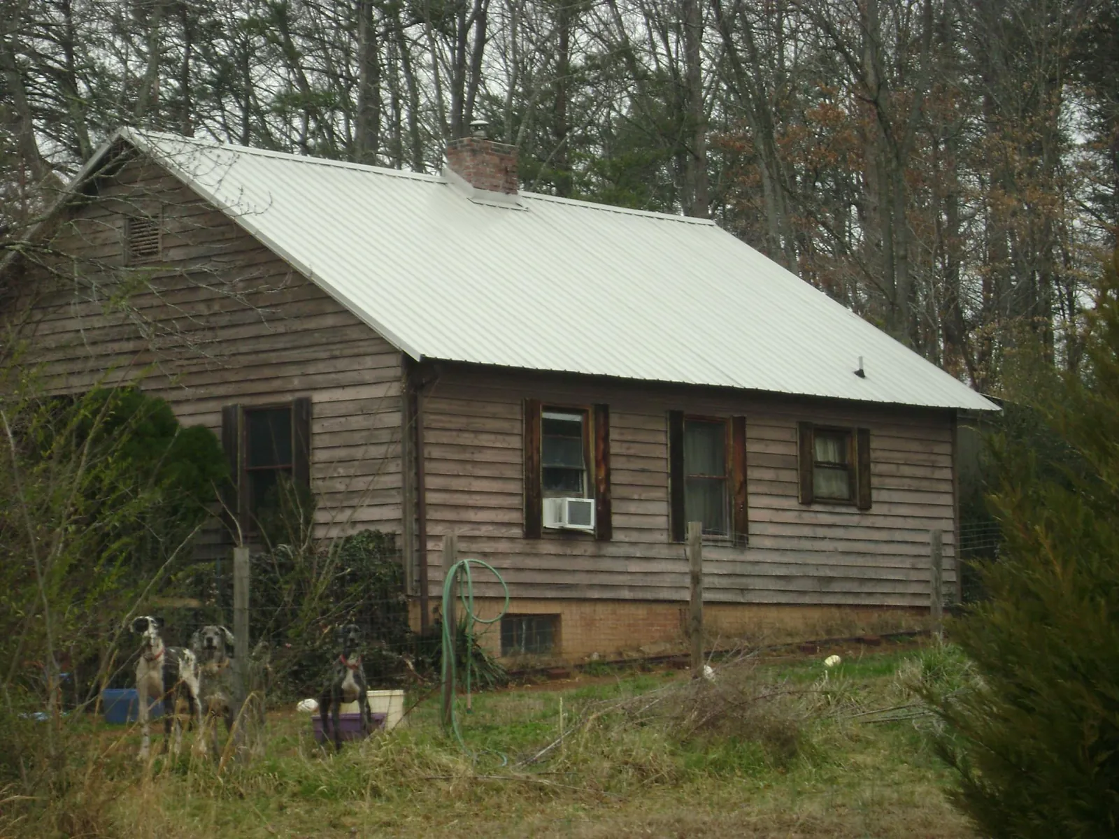 White metal roof on an old wood sided farmhouse, from a Metal Roof Installation job in Beasley
